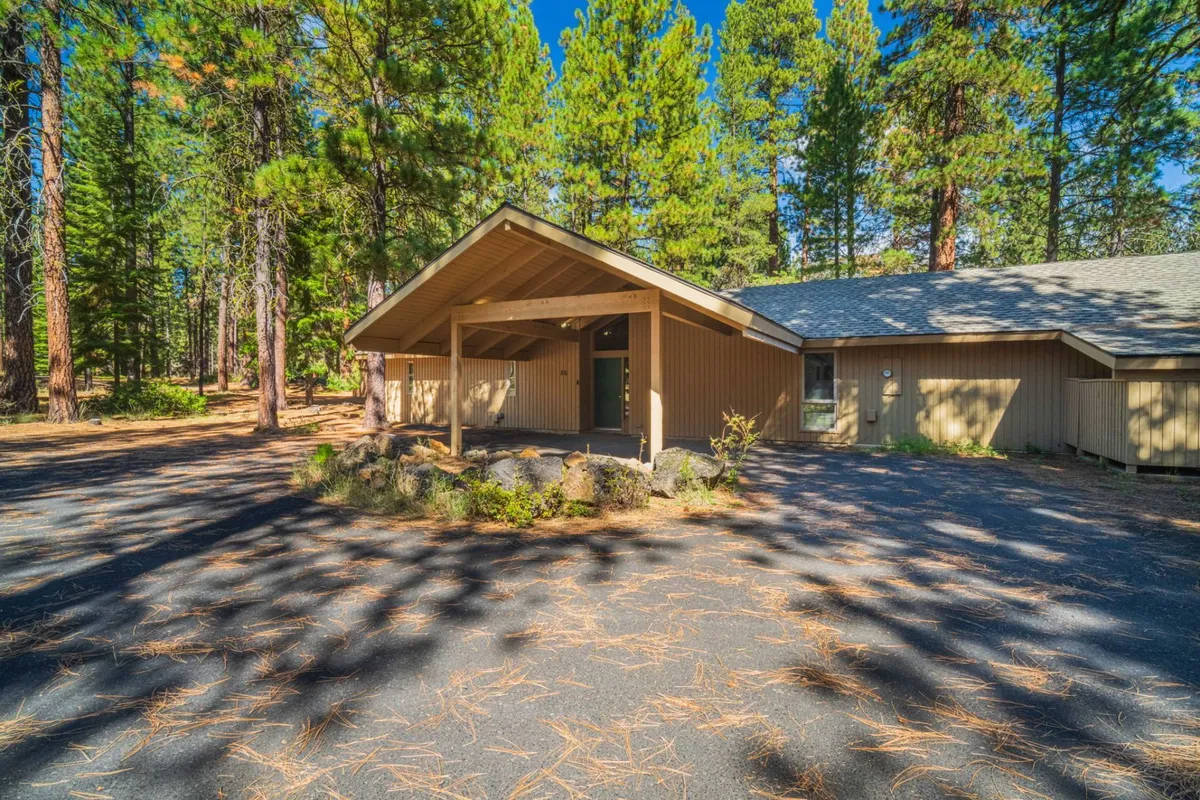 A welcoming front porch with comfortable seating, surrounded by rock landscaping and tall pine trees. The porch invites relaxation and is set in a quiet, natural environment, perfect for enjoying a morning coffee or evening conversation while immersed in the serenity of the ranch setting.