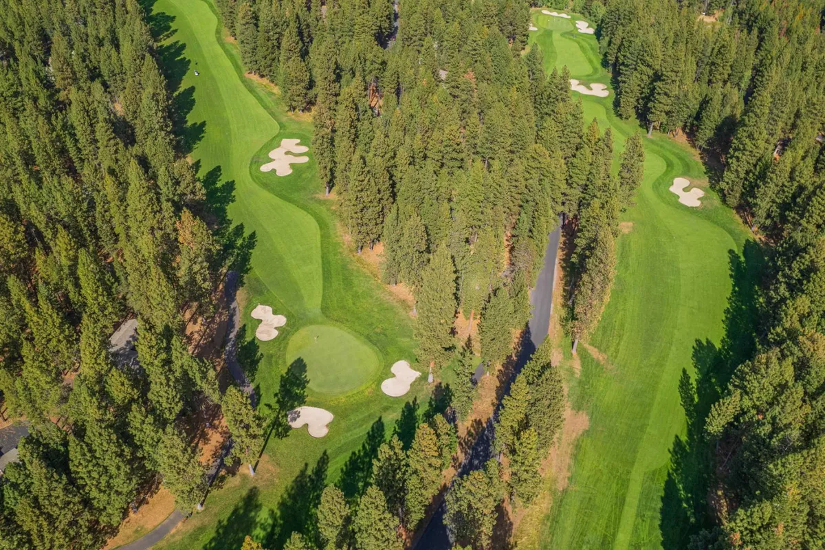 A sweeping view of the lush golf course greens, sand traps, trees, and pathways, offering a glimpse of the recreational amenities available to guests of all ages and interests. The peaceful landscape invites exploration and outdoor fun.